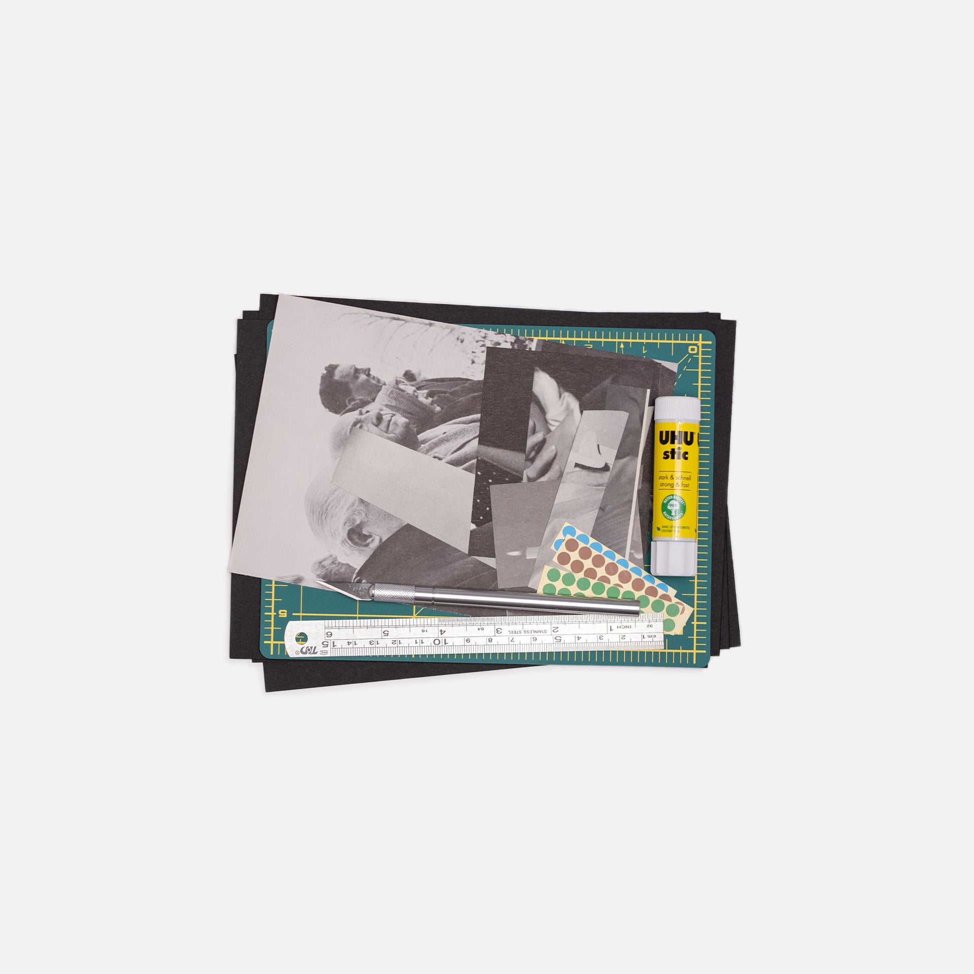 Stack of collage materials with a ruler and stickers on a white background.